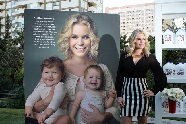 Rebecca Romijn, black and white striped skirt, black blouse, gold necklace, black ring